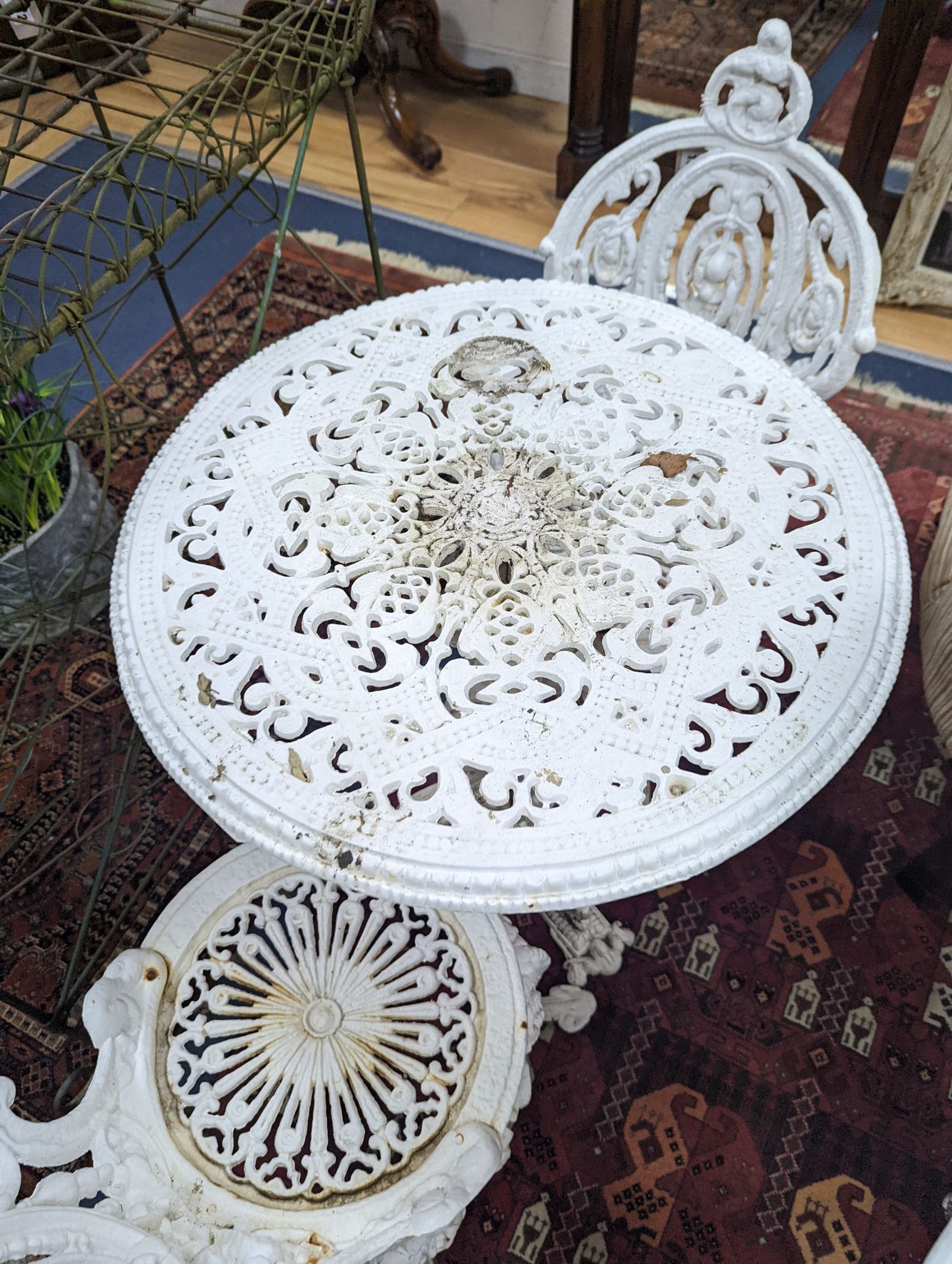 A Victorian Coalbrookdale style painted cast iron garden table, diameter 58cm, height 70cm and pair of chairs